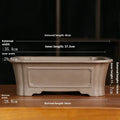 Classical rectangular purple sand bonsai pot with cut corners on a floor.