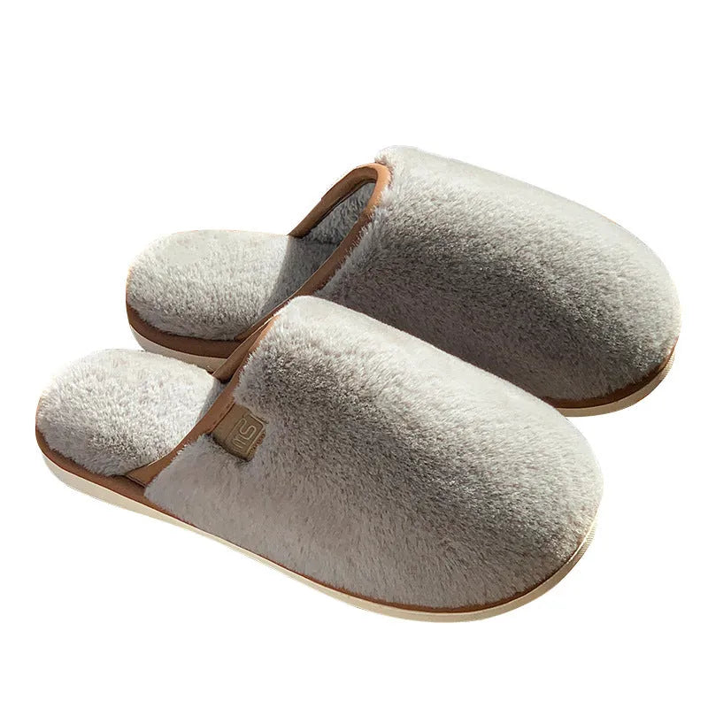 Pair of solid colour plush PVC winter slippers with non-slip soles for home use.