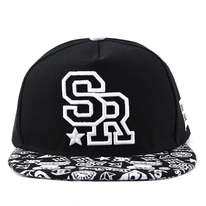 Black cotton baseball cap with white letter embroidery on the front, showing adjustable strap.