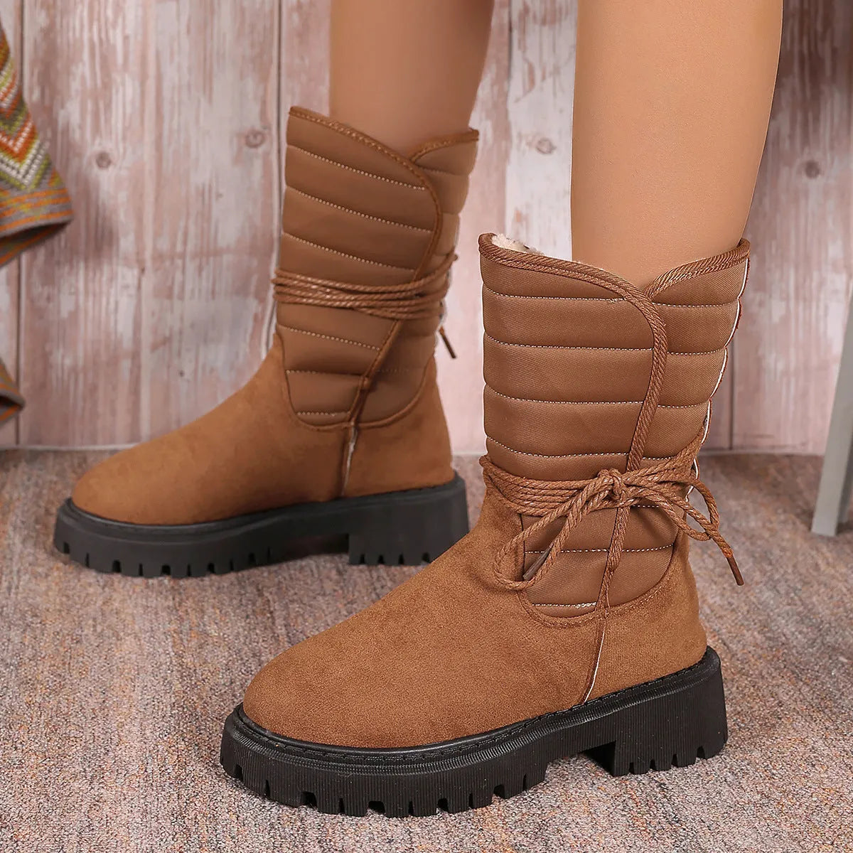 Women's chunky heel snow boots in suede with lace-up design and fleece lining, shown in black.