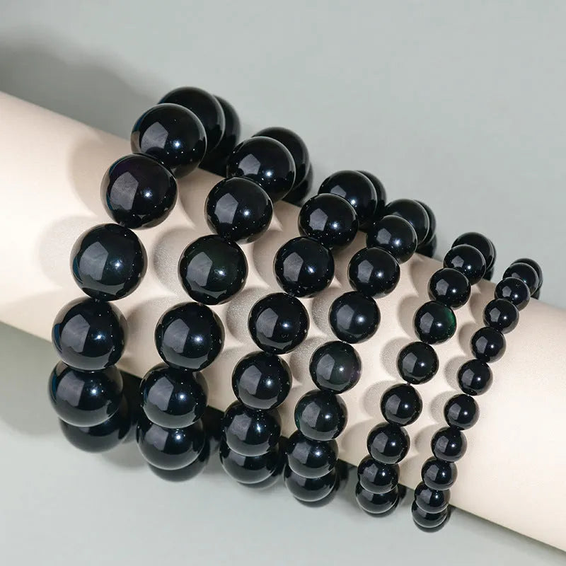 Hand-woven obsidian couple bracelets in various colours including black, silver, and rainbow eye obsidian
