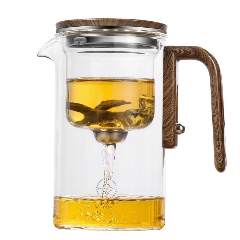 Glass teapot with wooden handle showing magnetic separation mechanism for loose leaf tea brewing