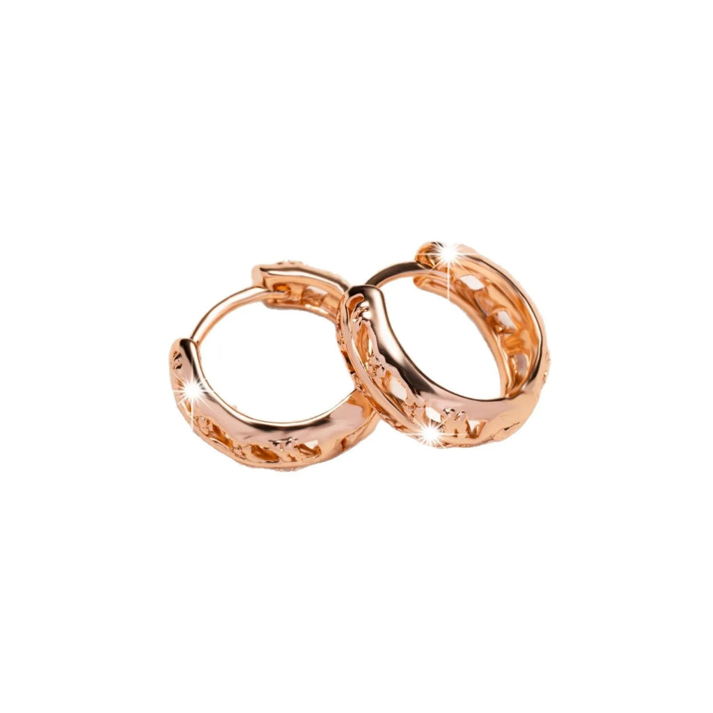 Small copper earrings with a hollow leaf and heart design in a rose gold finish.
