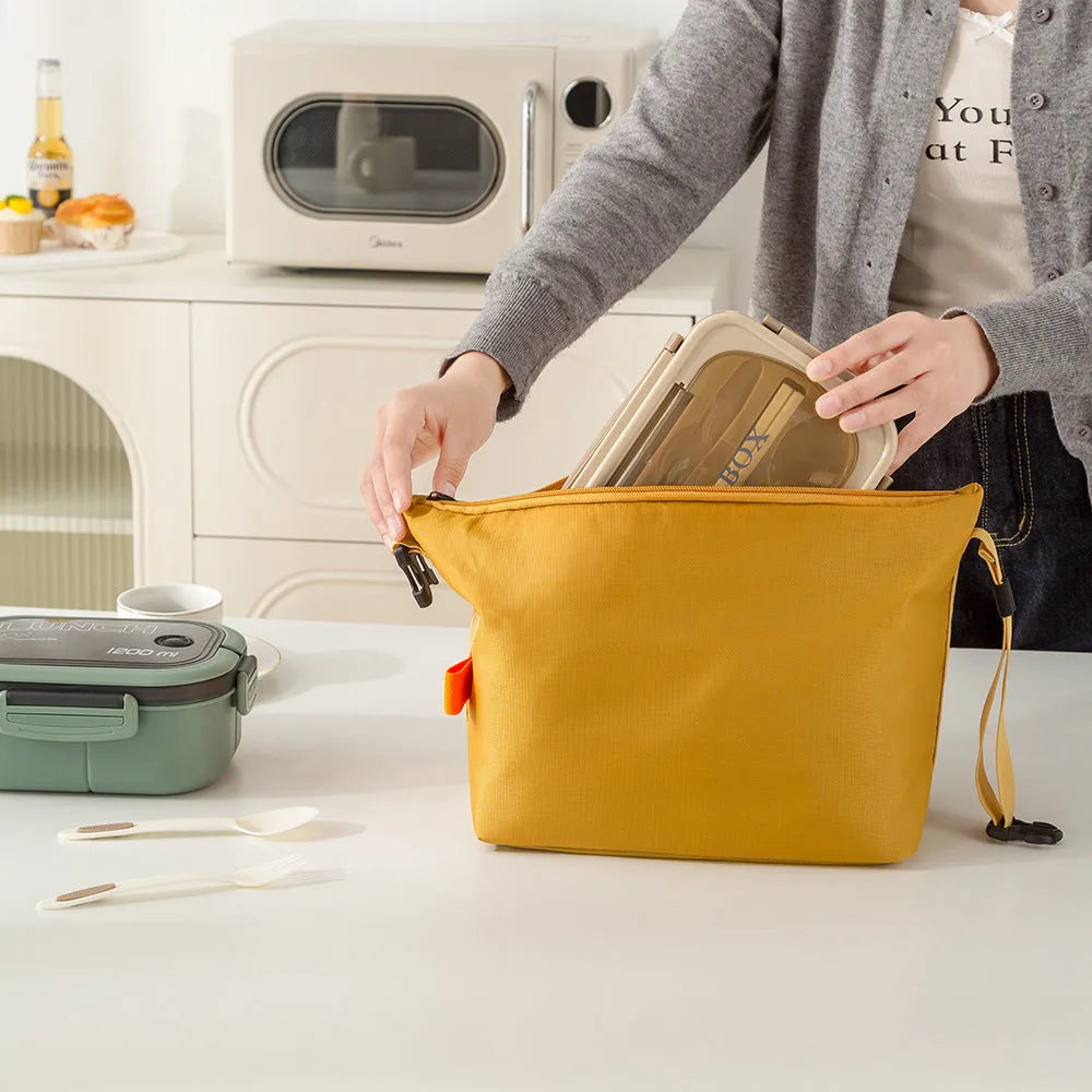 Japanese style insulated lunch bag in Oxford cloth shown in one of four colours: Army Green, Black, Grey, or Yellow.