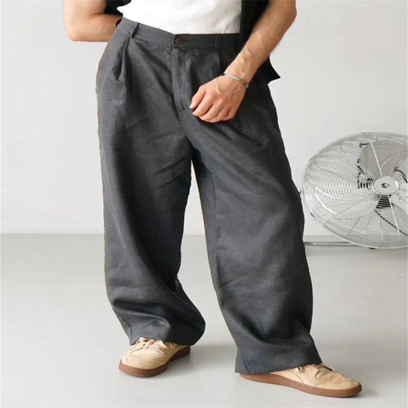 Men's loose fit pleated high waist jogger pants in a light grey colour, showing the casual straight-leg style.