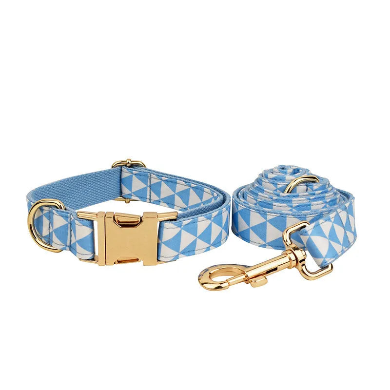 Blue cloth dog vest harness set with matching collar, leash, and decorative bow tie on a small dog