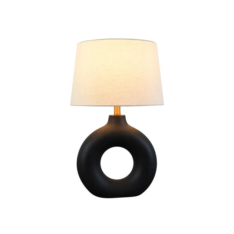 Small white Feng pottery Japanese-style table lamp with button switch on a desk.