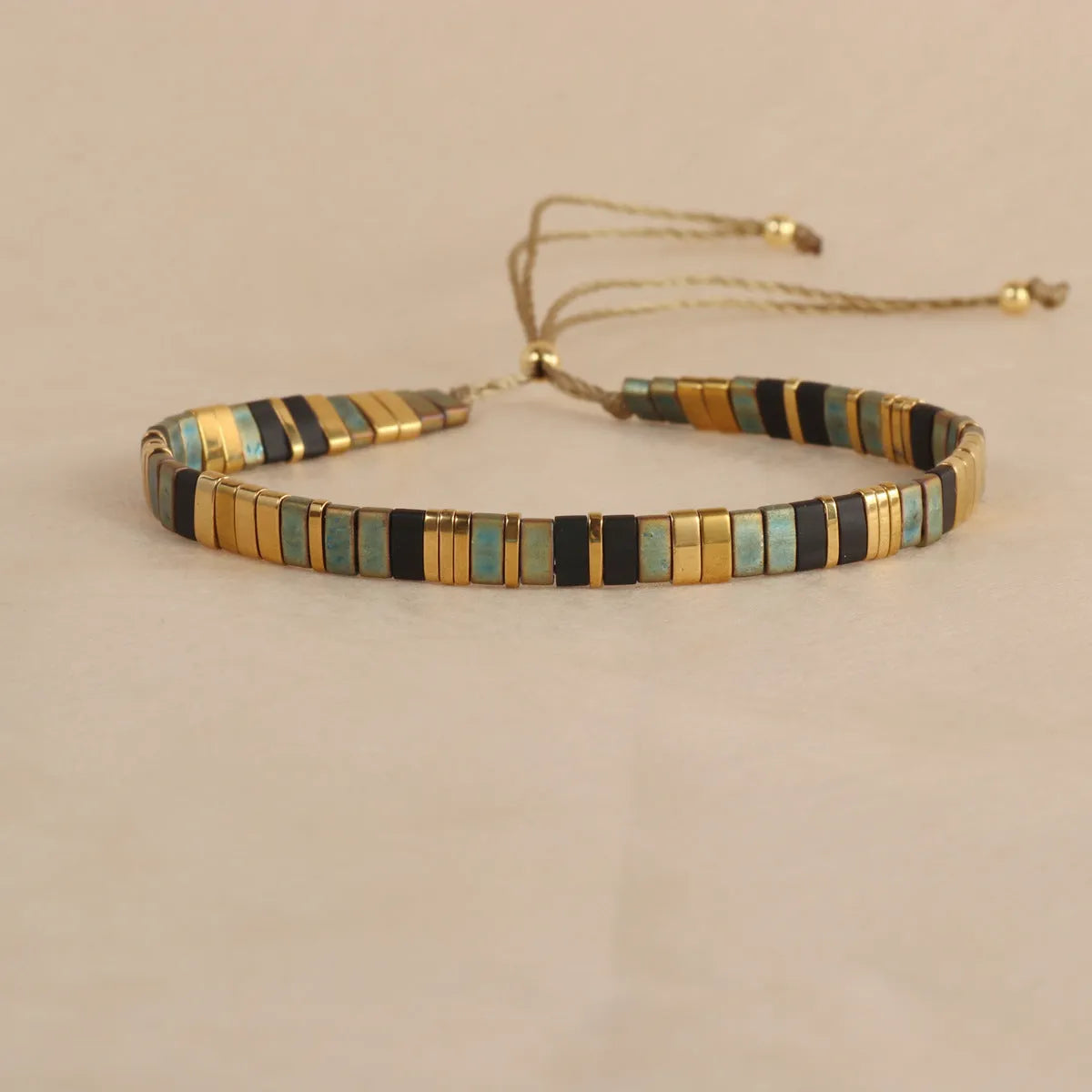 Geometric beaded bracelet with round elements in milky white, black, green, blue, or red.