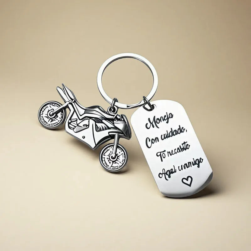 Stainless steel motorcycle keychain with inspirational design, shown with its included flannel storage bag.