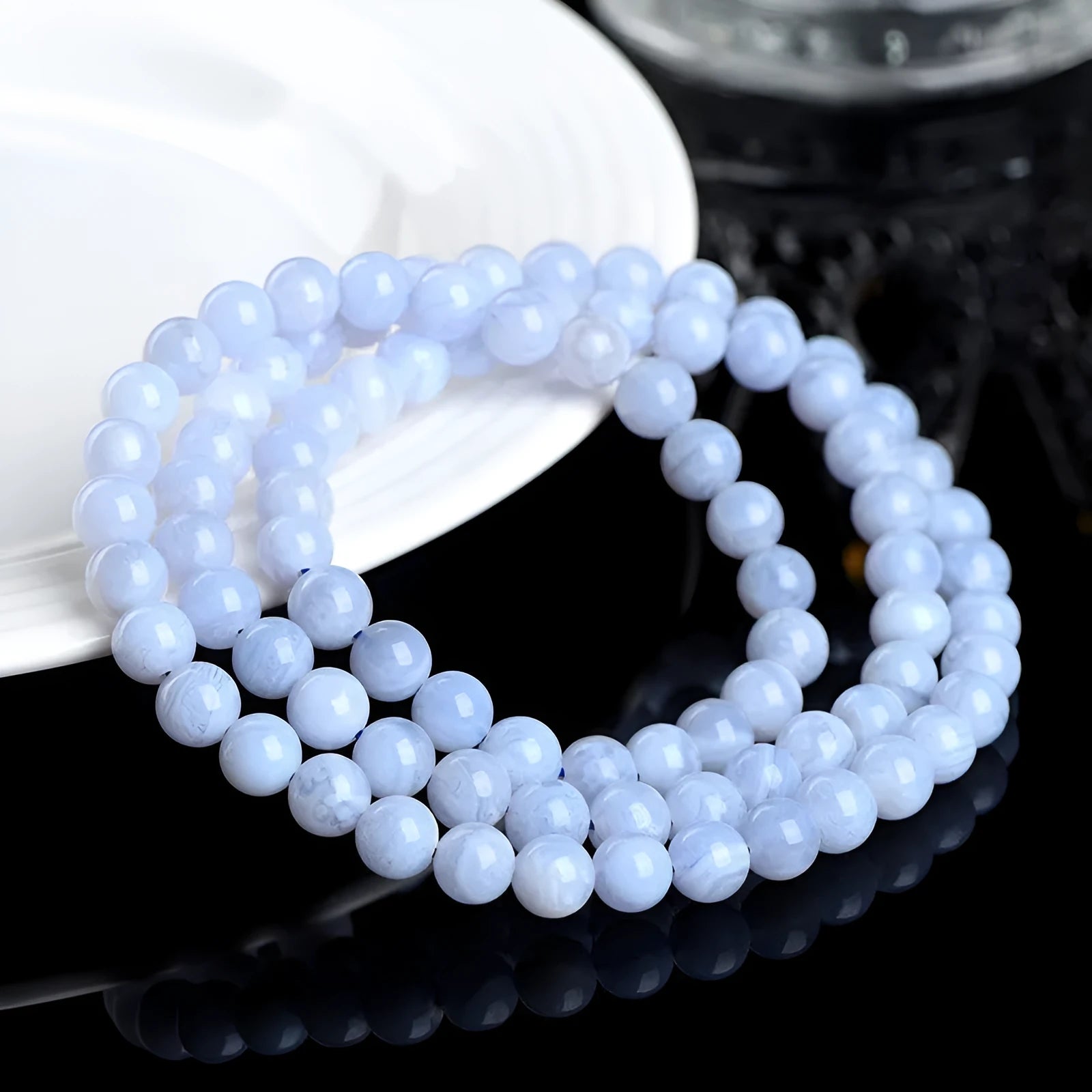 Natural blue agate bracelet showing scattered beads with blue striped pattern and three-circle design