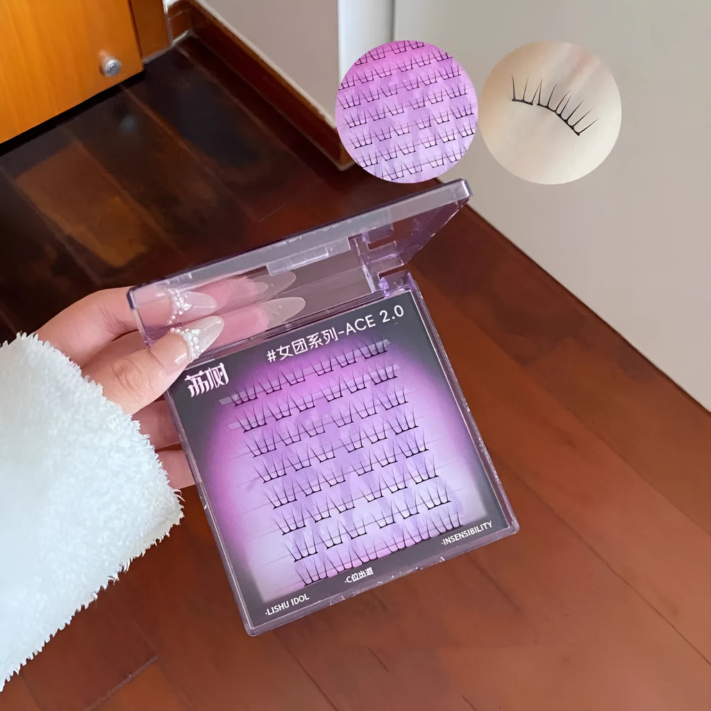 Pack of reusable individual false eyelash clusters with glue and tweezers on a pink background