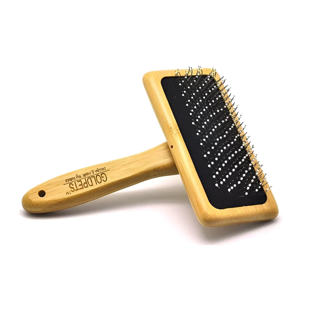 Goldpets bamboo handle pet slicker brush with stainless steel pins on wooden surface