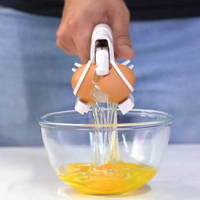 White handheld egg shell cracker with curved silicone grip and metal mechanism on a kitchen counter