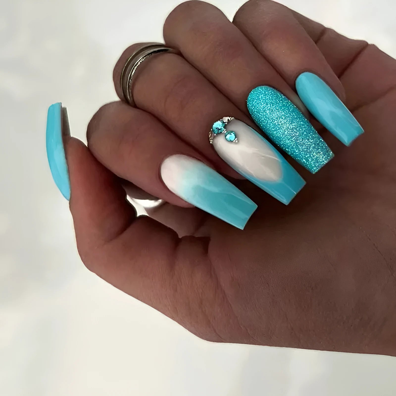 Solid colour artificial nails with long ballet shape and blue diamond glitter decoration