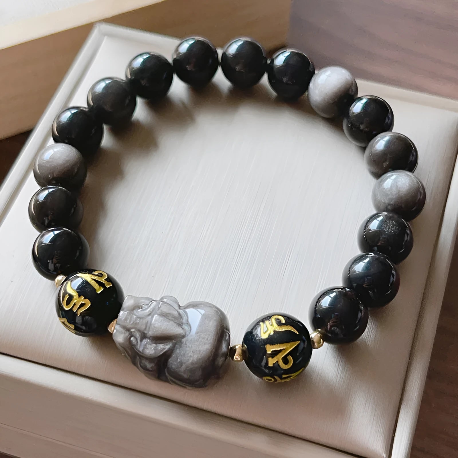 Men's silver stone beaded bracelet with zodiac and Chinese proverb charms on a wrist.
