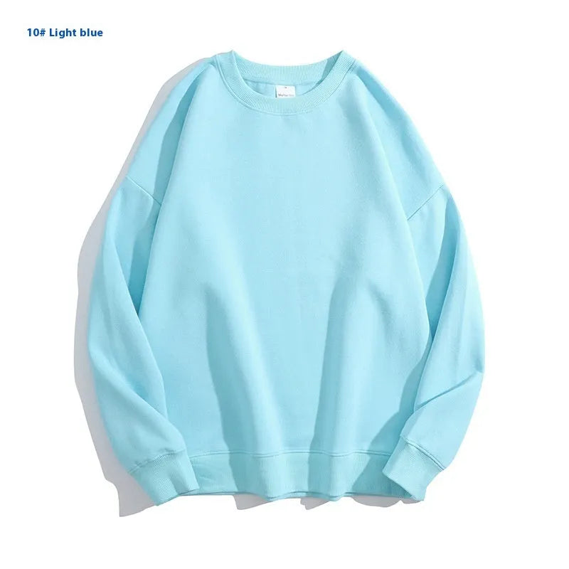 A woman wearing a loose, light blue, cotton off shoulder sweater with long sleeves and a round neck.