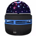 Silver LED galaxy projector lamp with acrylic shade on a table, showing starry light projection on a blue wall.