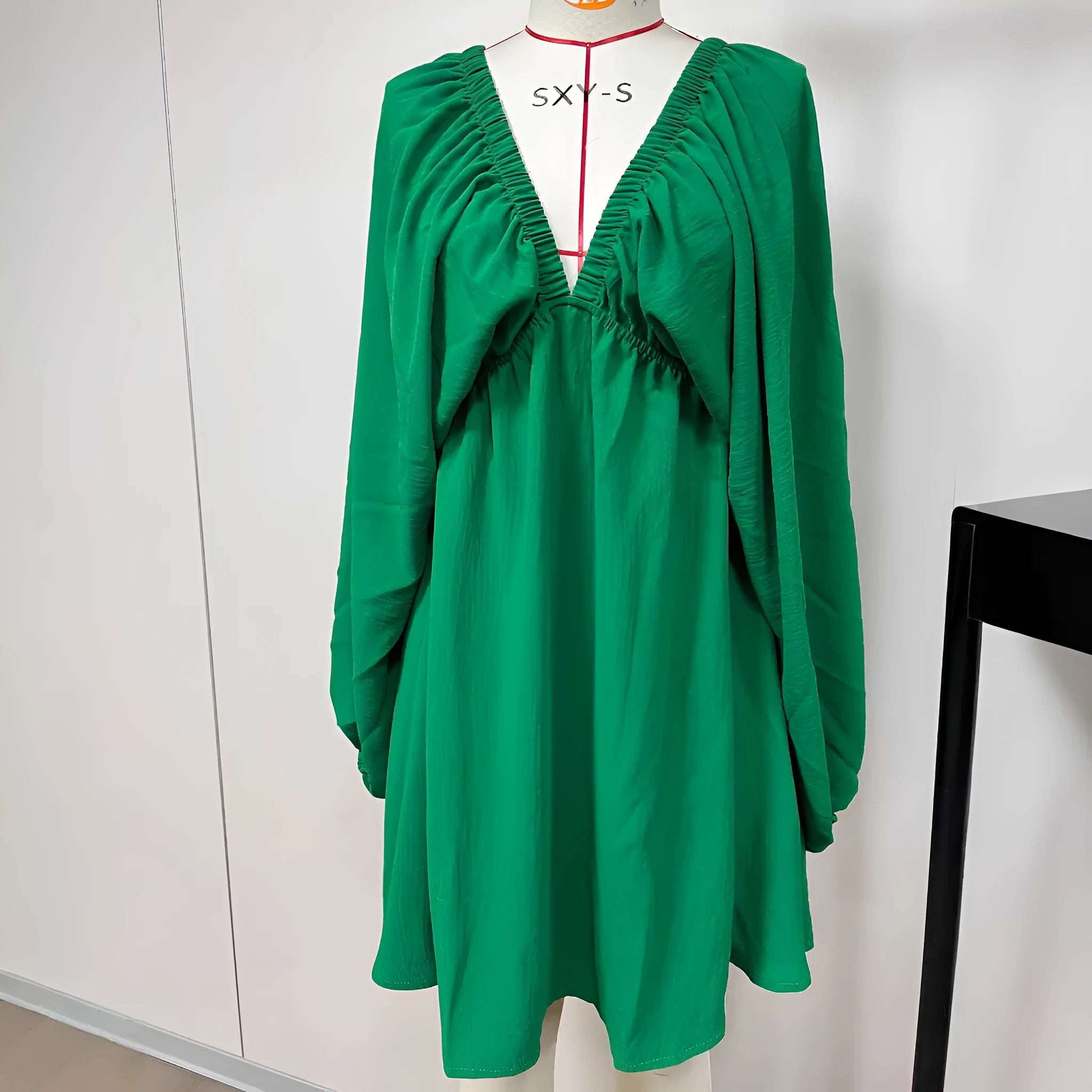 Women's apricot V-neck long-sleeve dress with puff sleeves and a flounce swing skirt on a hanger.