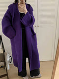 Loose grey hooded sweatshirt cardigan coat with raglan sleeves on a hanger.