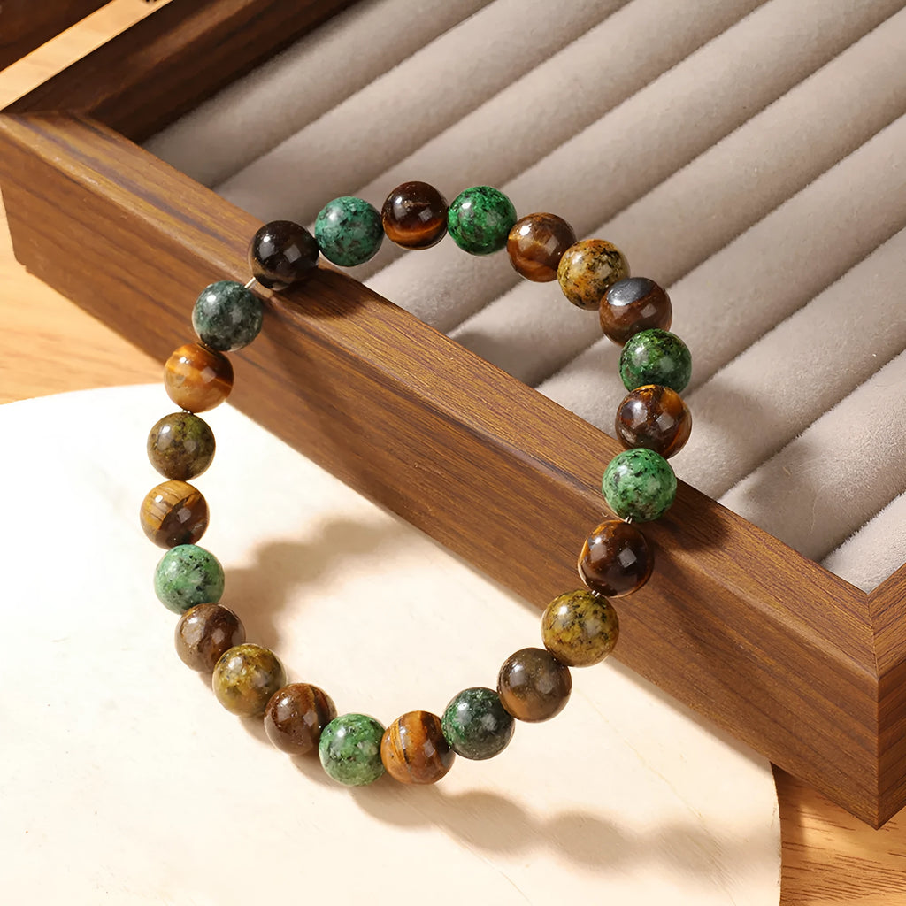 Handmade tigereye stone bracelet with 18mm flower bead in antique style on wrist.