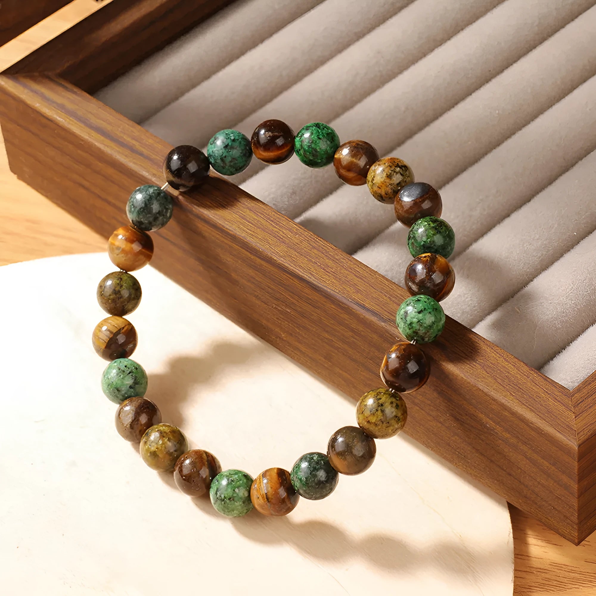 Handmade tigereye stone bracelet with 18mm flower bead in antique style on wrist.