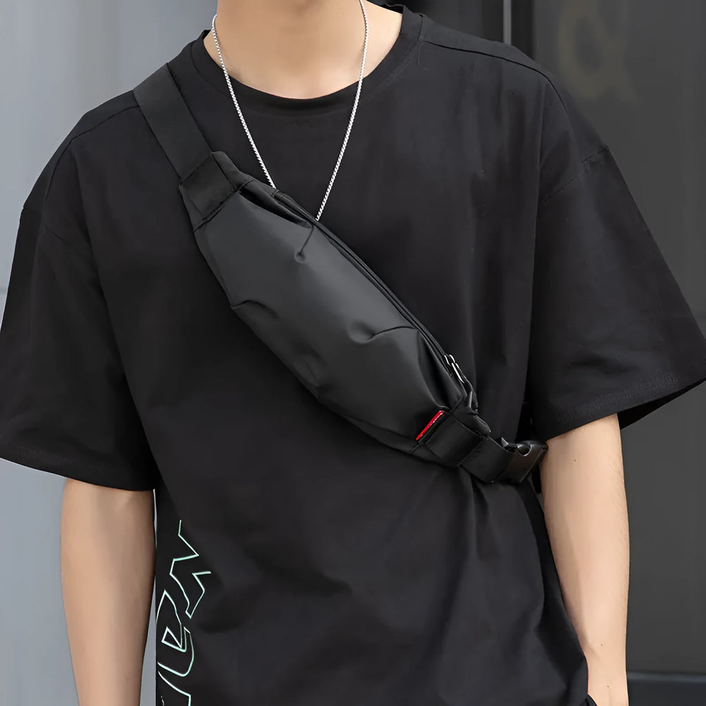Black Oxford cloth crossbody waist pack for men showing front zipper and internal phone pocket.