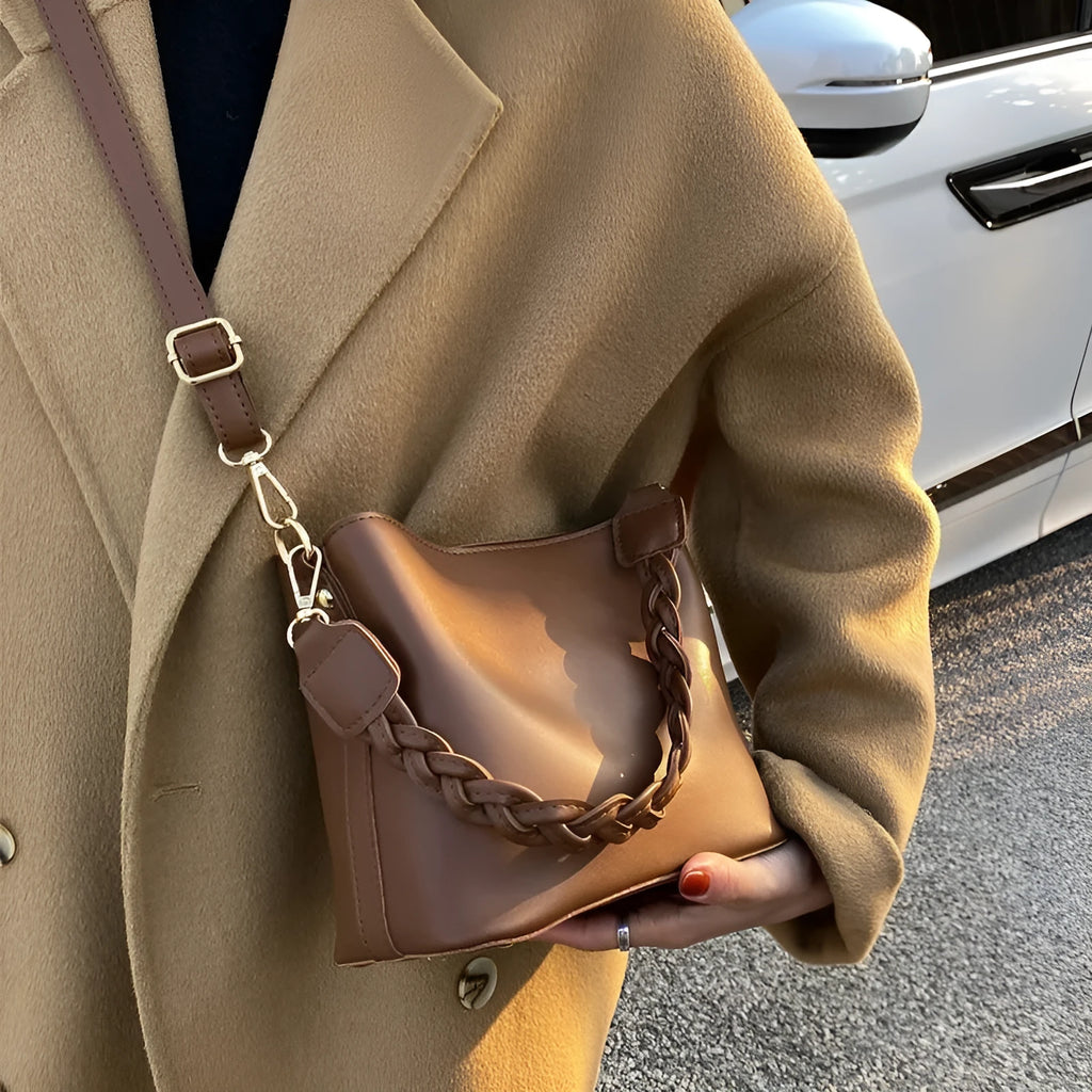 Khaki PU leather bucket bag with woven texture and a crossbody strap.