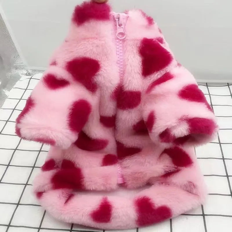 Small dog wearing plush warm coat in pink colour for cold weather protection