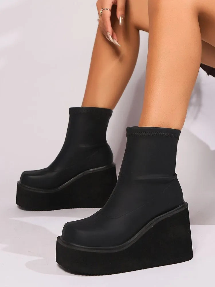 Black plus size women's ankle boots with a wedge heel and round toe.