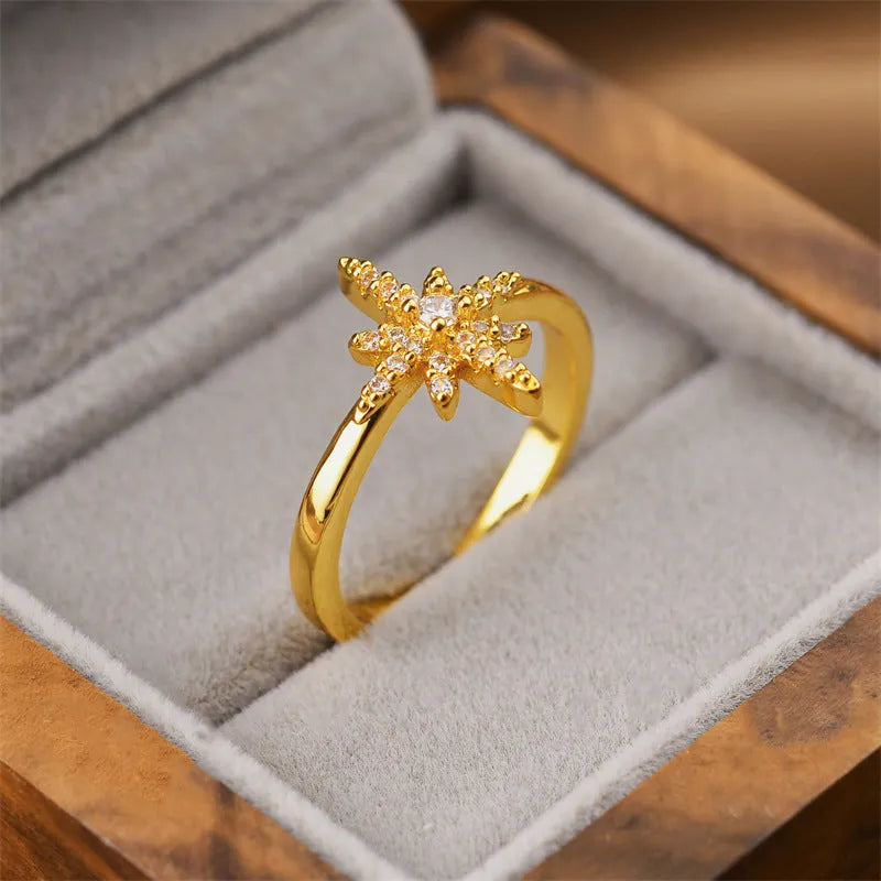 Women's gold geometric open band fashion ring on a hand.