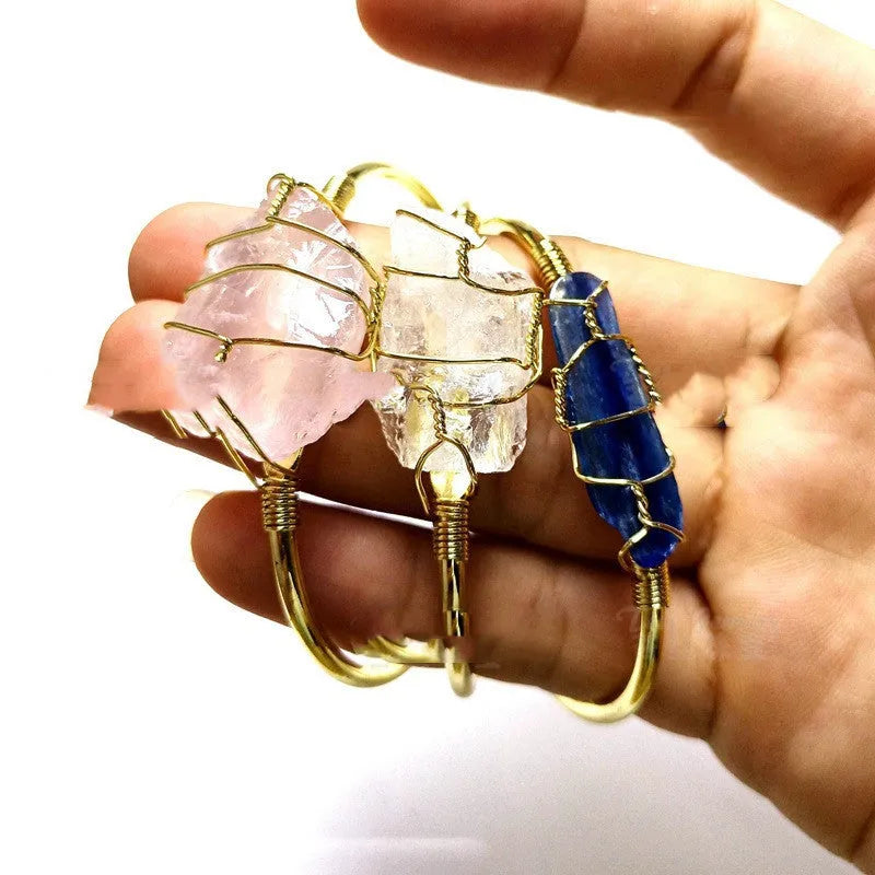 Unisex geometric bracelet with rough natural crystals and gold winding metal on a wrist.