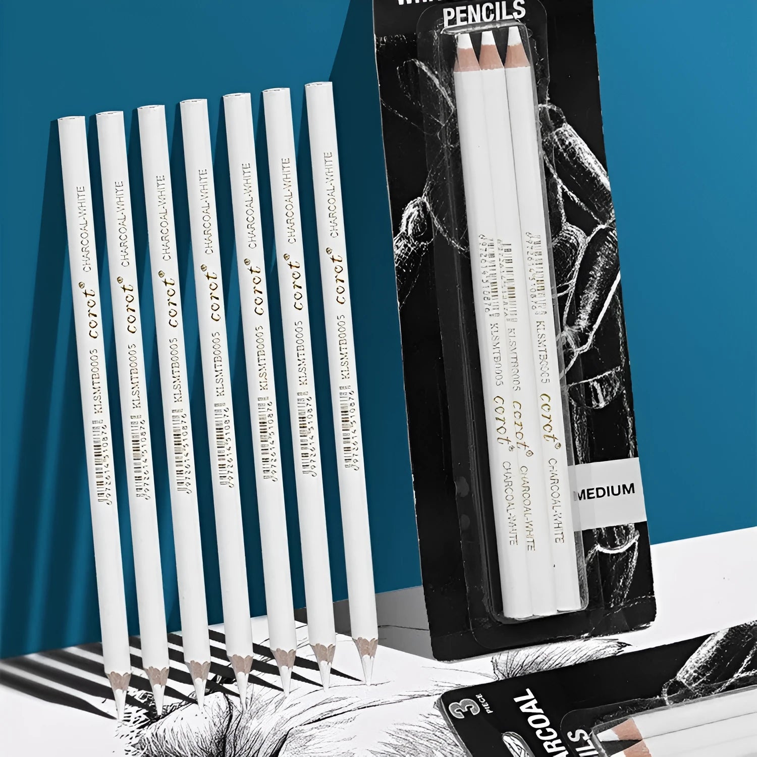 Set of three white charcoal drawing pencils with wooden casings.