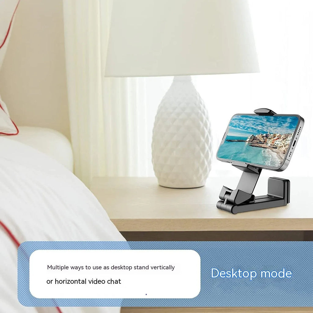 Foldable rotating phone holder in black, shown in use with a mobile phone on a desk