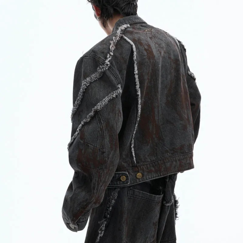 Black gradient distressed denim coat with padded shoulders and matching trousers, featuring raw edges and splash-dye finish.