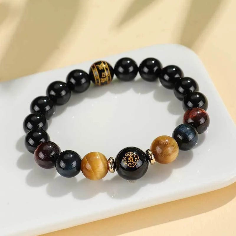 Black agate beaded bracelet with carved Buddhist charm and tiger eye stones