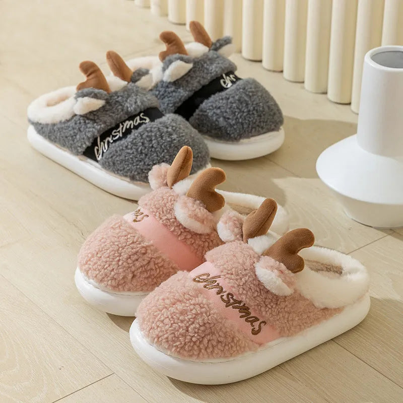 Pair of Christmas elk winter home slippers with suede upper and candy-coloured antler print on bedroom floor