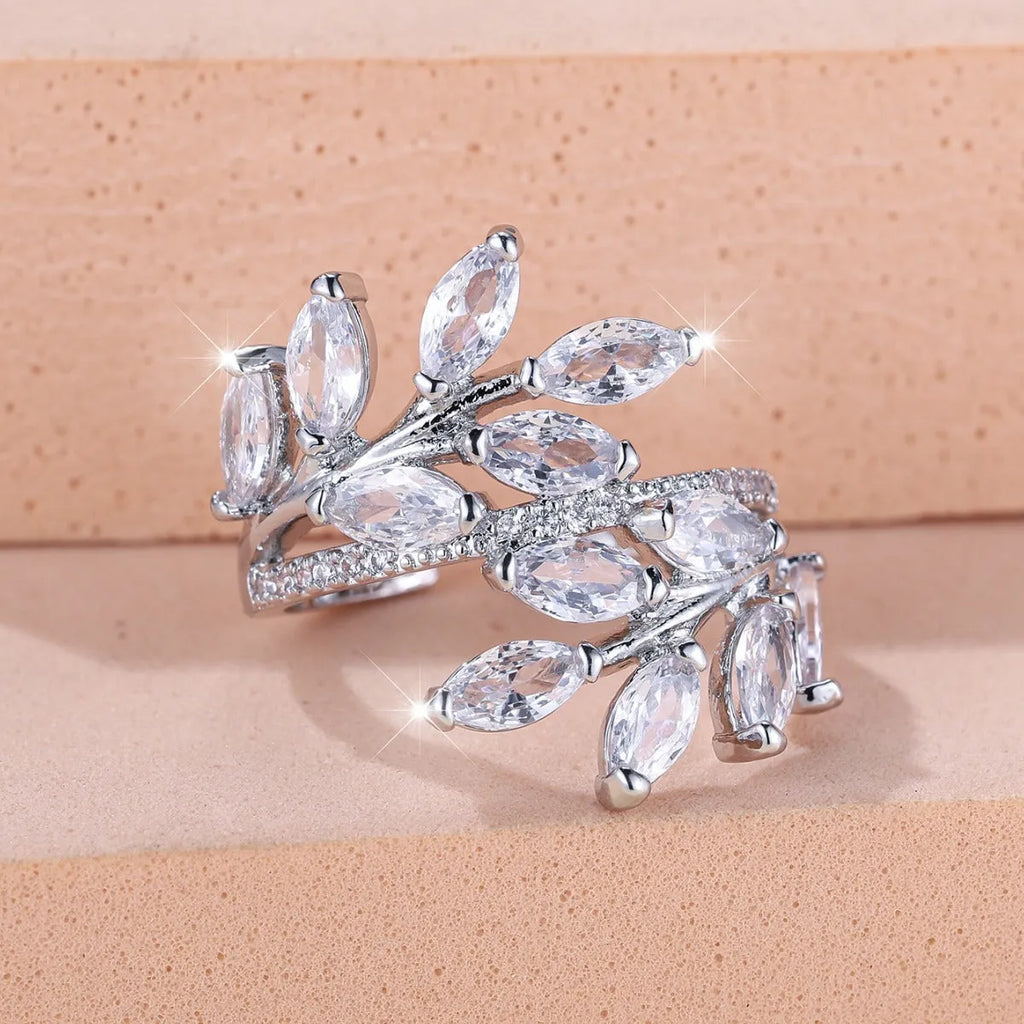 Adjustable copper leaf-shaped ring with zircon stones in various colour options on a white background.