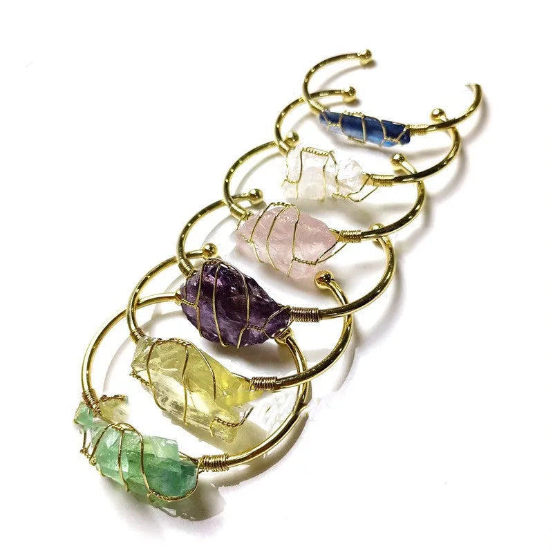 Unisex geometric bracelet with rough natural crystals and gold winding metal on a wrist.