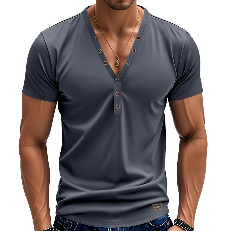 Man wearing a loose fit light blue V-neck pullover top with a button detail.