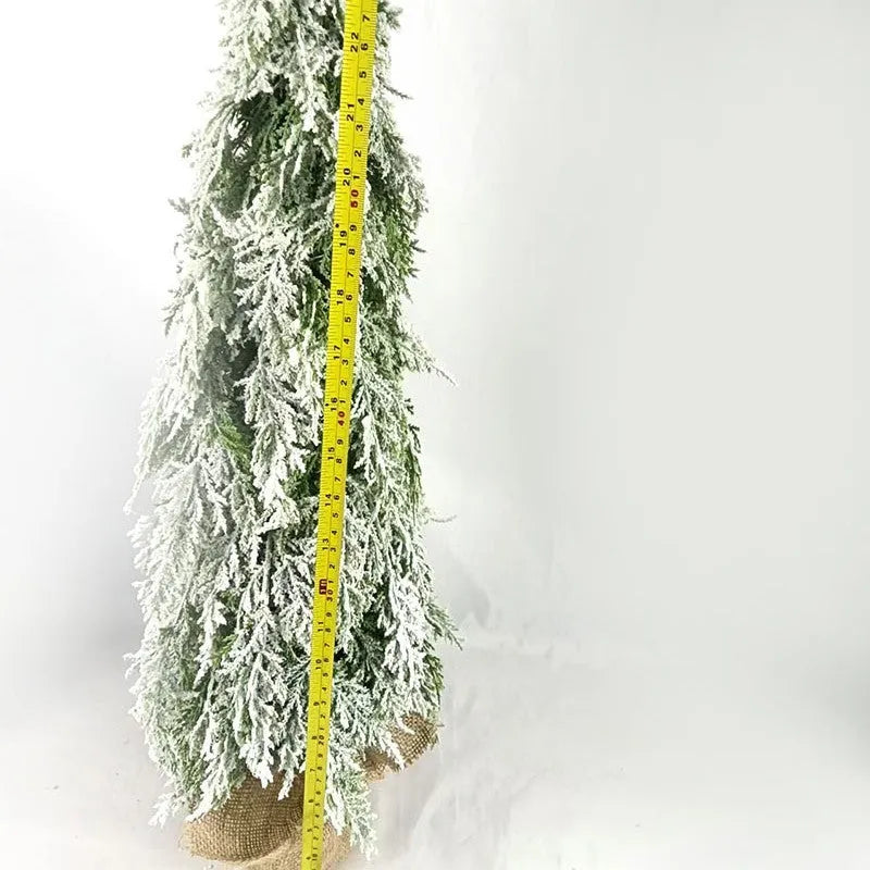 Small 24-inch white snow spray Christmas tree with integrated lights on desktop