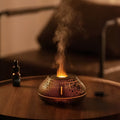 Round white flame effect aroma diffuser humidifier with colourful LED lighting on wooden desk