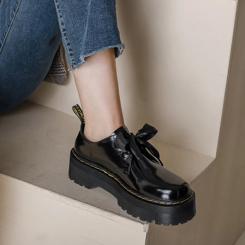 Women's black thick soled leather shoes with cross straps and lace-up closure