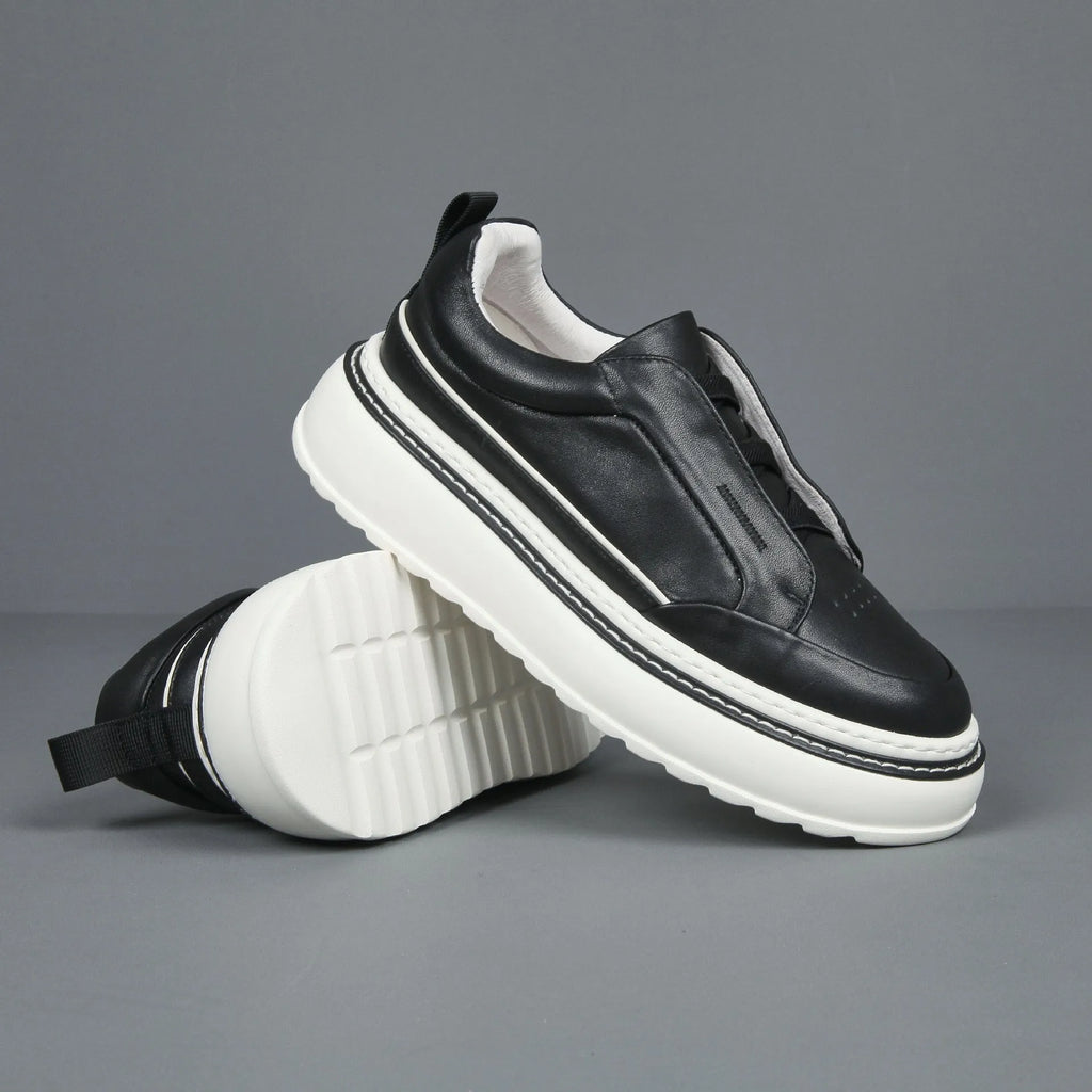 Black casual slip-on sneaker with leather upper, foam platform sole, and elastic band – side view