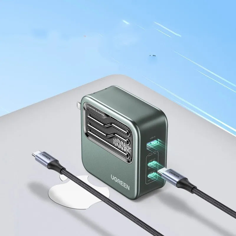 100W Gallium Nitride fast wall charger with USB-C port on a desk next to a laptop.