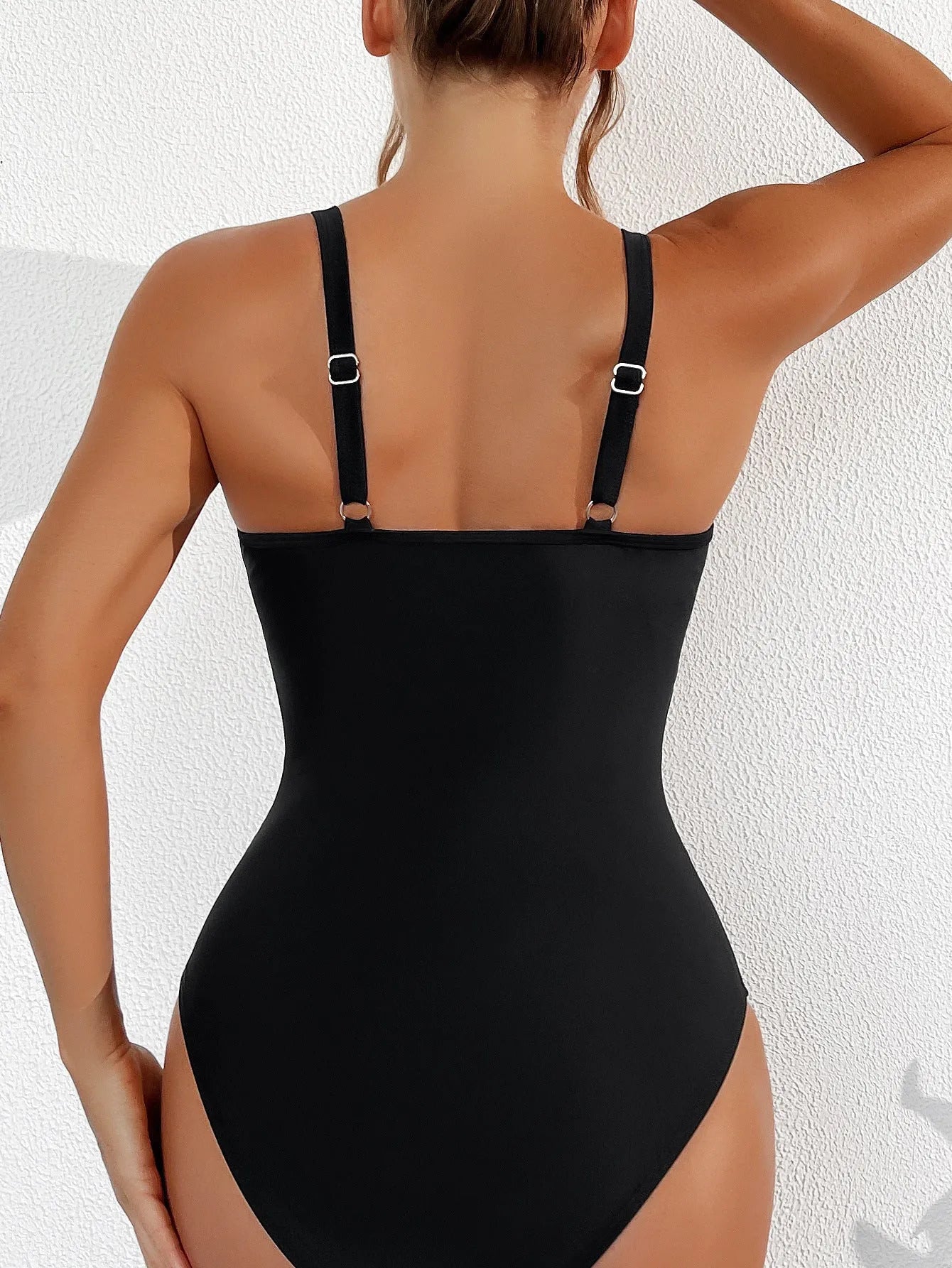 Black sleeveless one-piece swimsuit with halter neck for women.