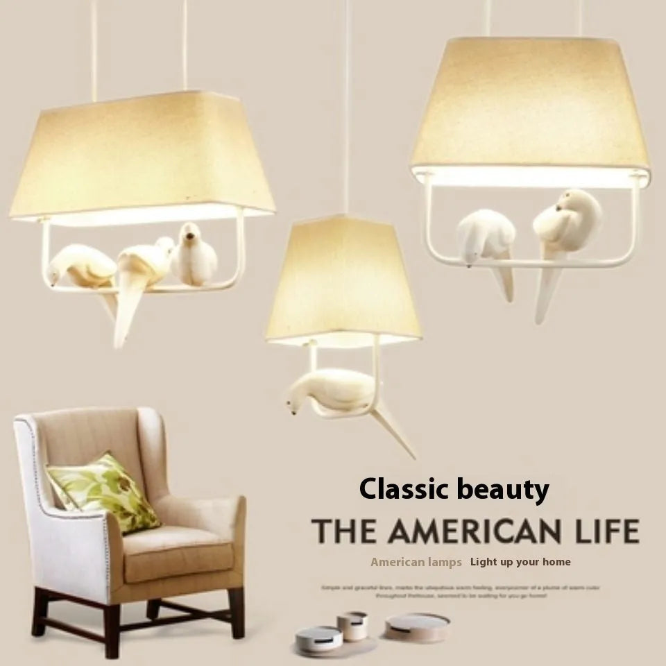 Iron ceiling chandelier with fabric shades featuring bird designs, hanging as a droplight.