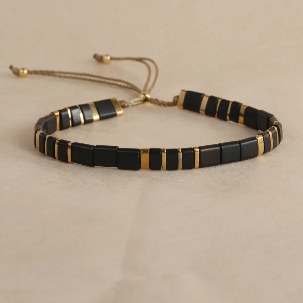 Geometric beaded bracelet with round elements in milky white, black, green, blue, or red.