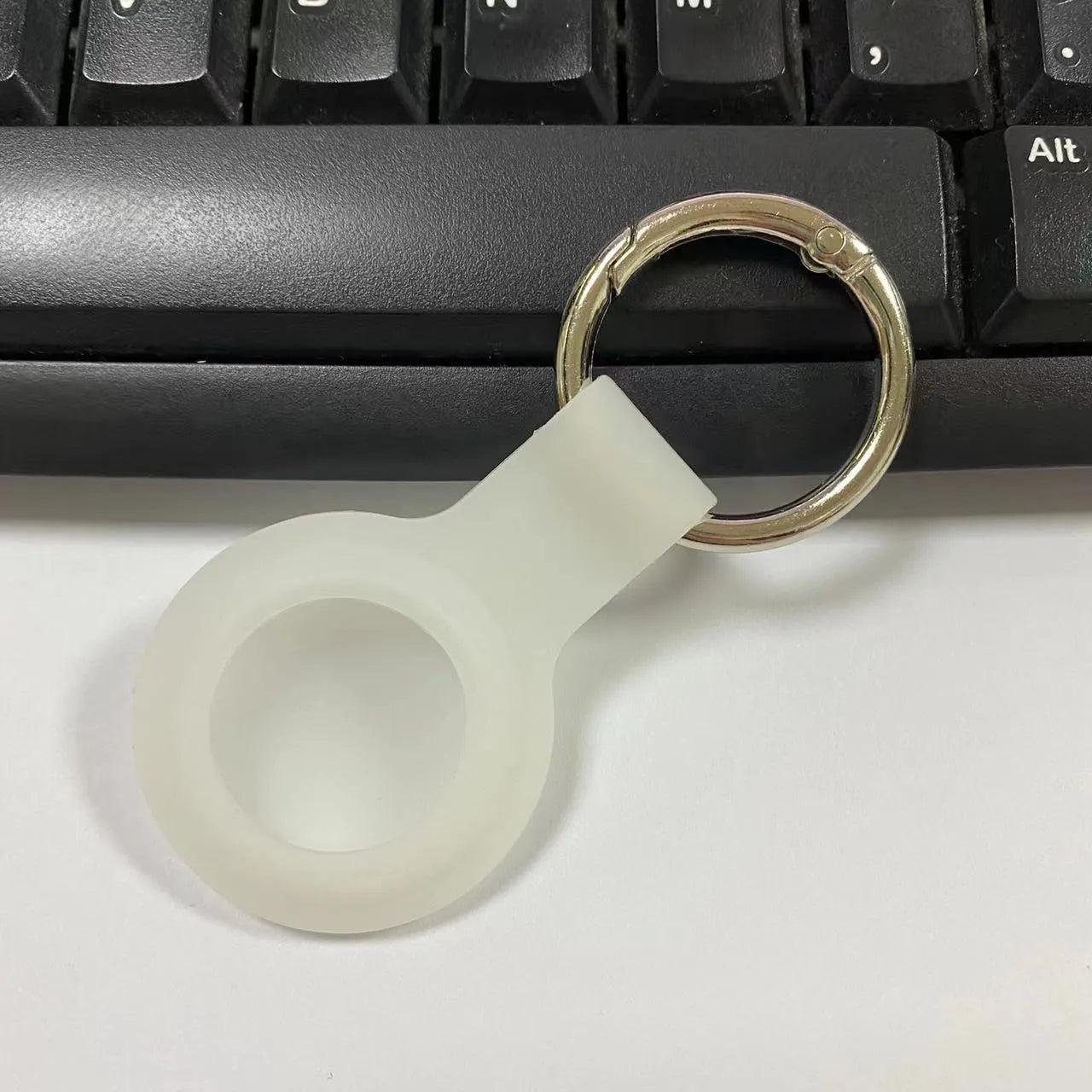Silicone protective case for Apple AirTag with metal snap button in assorted colours on a keyring.