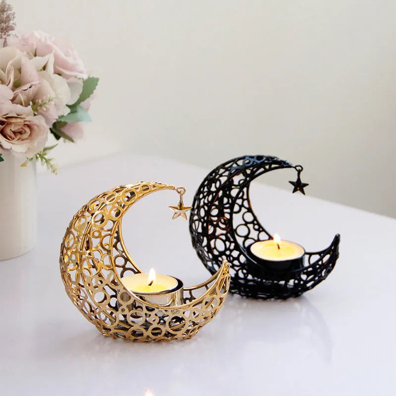 Gold crescent moon metal candle holder with hollow pattern on a wooden table