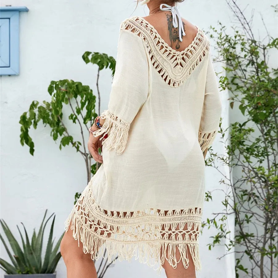 Women's apricot crocheted patchwork beach dress with half sleeves on a hanger.